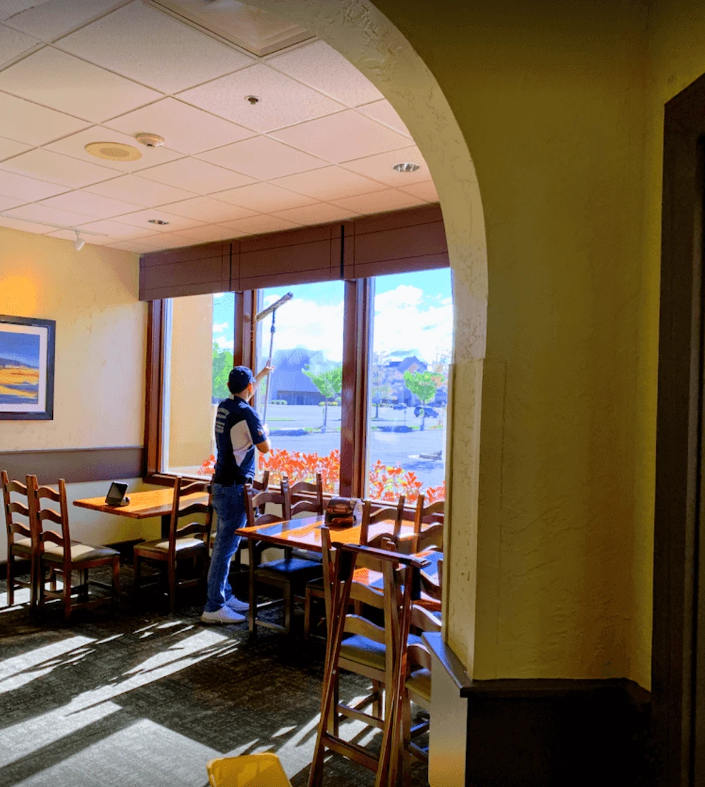 A man from Bethany Associates cleaning window in a kitchen